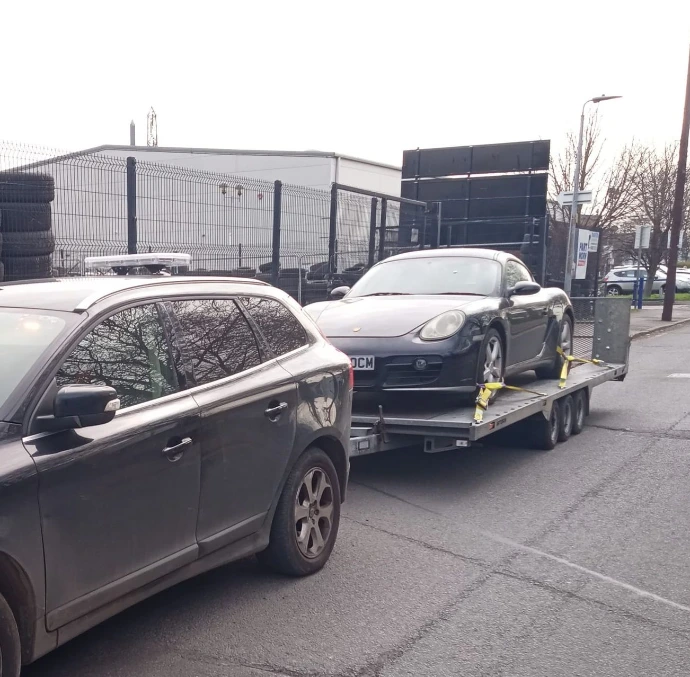 Black car being recovered during the day